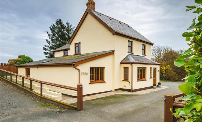 Large cream house with wooden windows and plenty of parking.